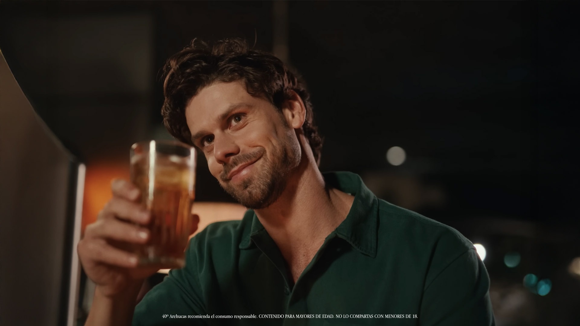 Arehucas 7 — A man in a green shirt holding a glass of beer.
