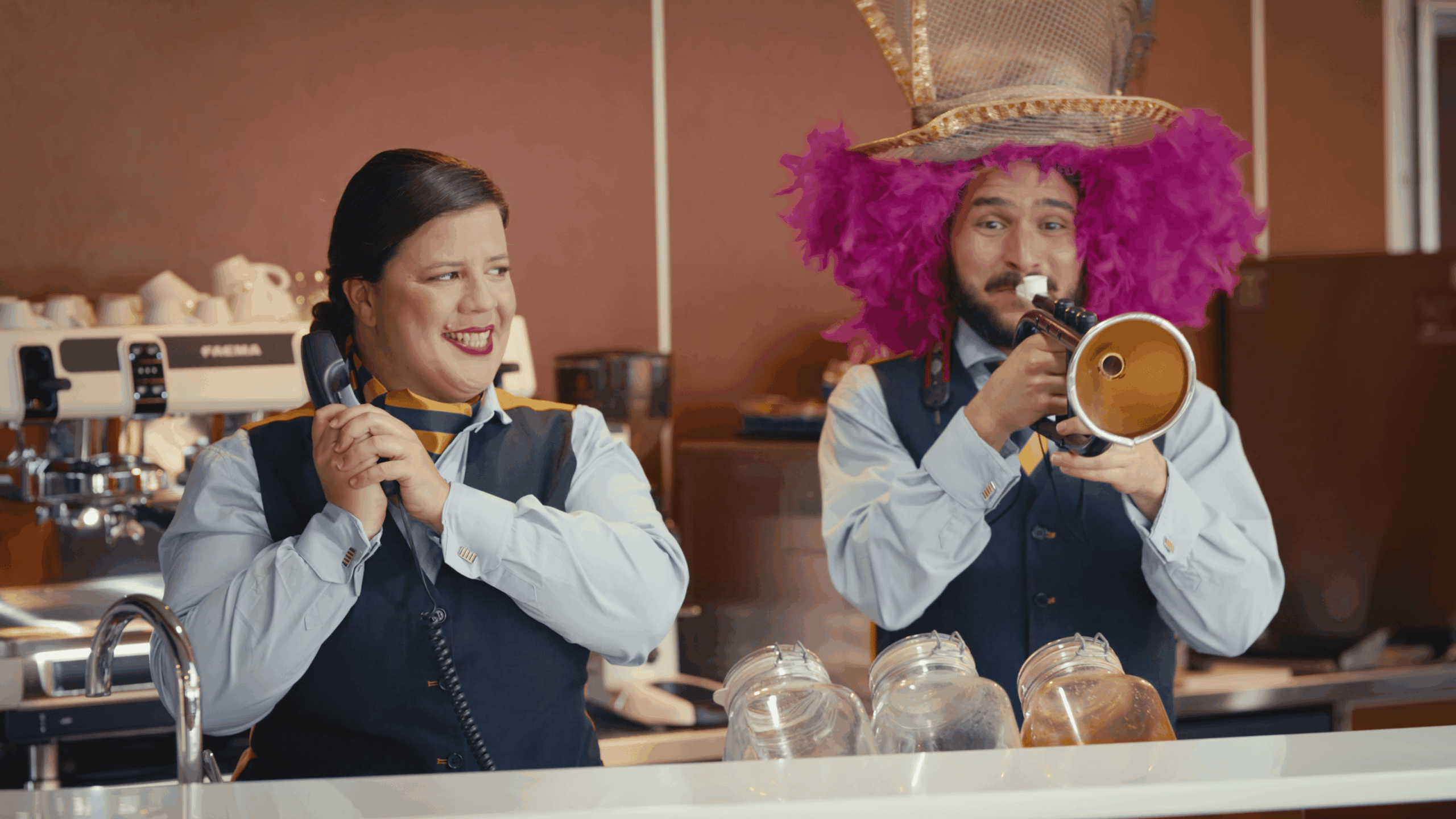 Fred.Olsen Carnaval 26 — A man in a pink wig and a woman in a blue shirt are talking on a phone.