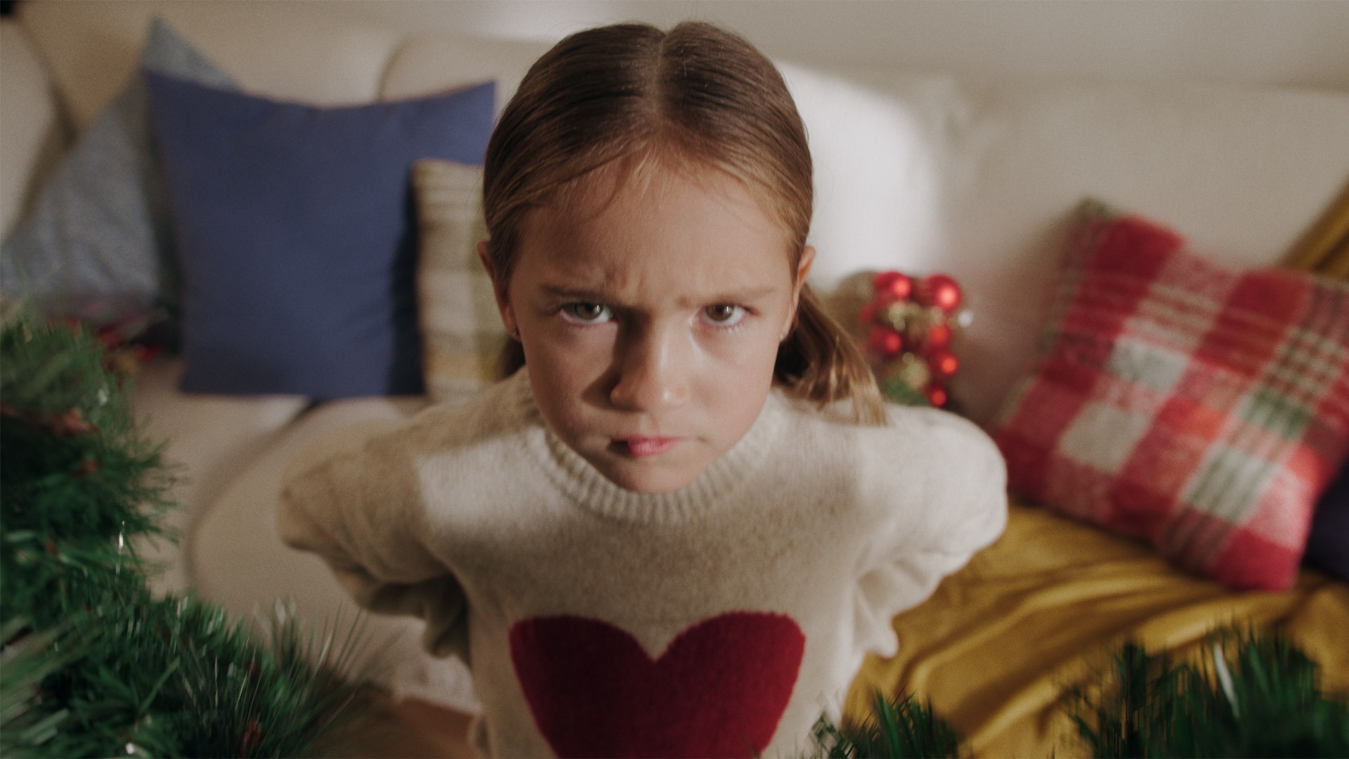 !Y un jamón¡ — A young girl with a heart sweater and a frown on her face.